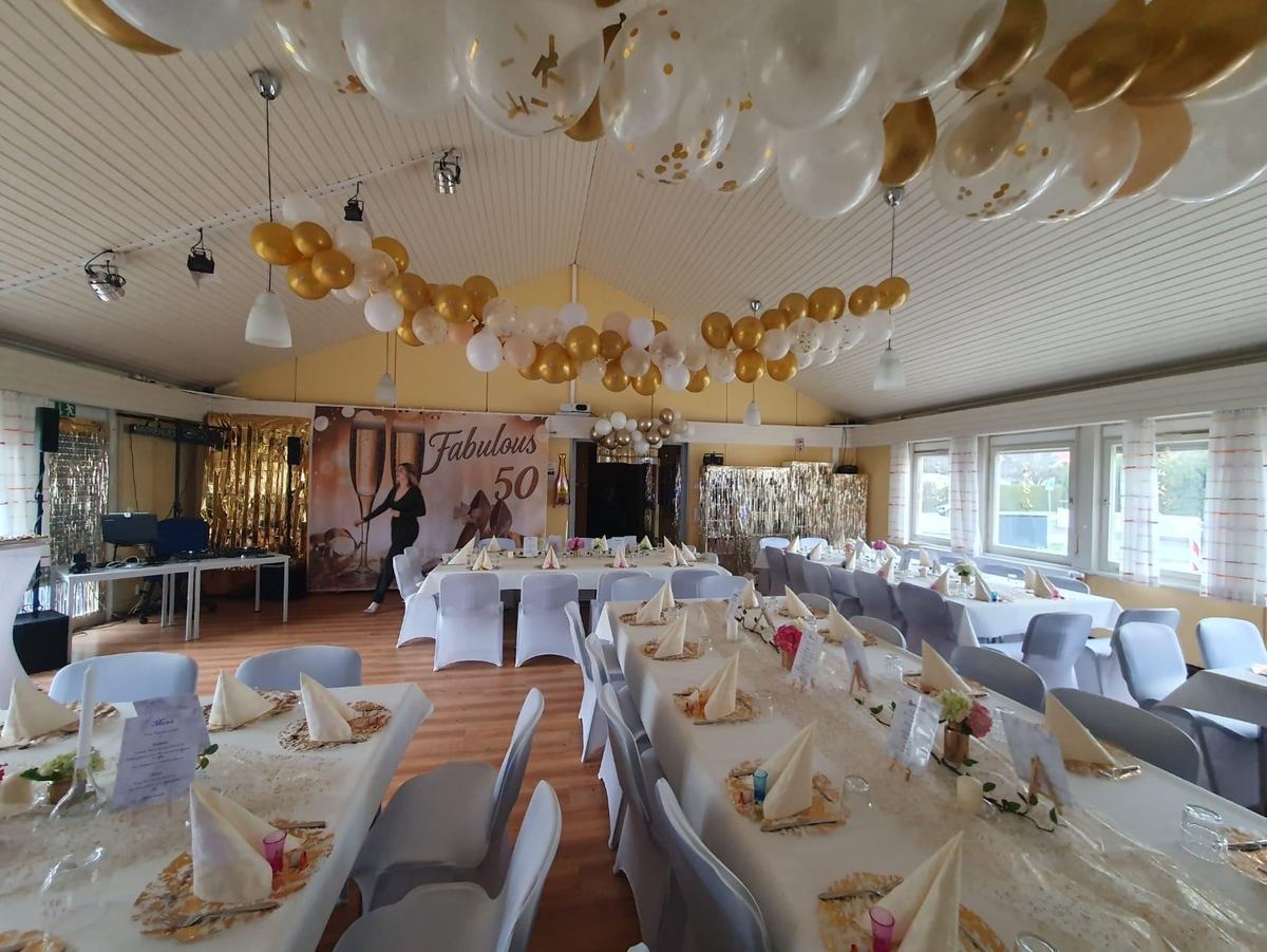 Saal zum 50. Geburtstag mit Ballondecke in Weiß und Gold